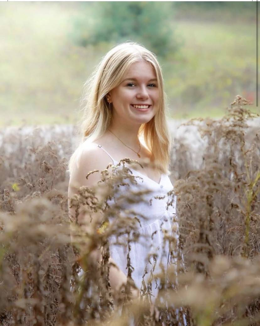 Olivia Darroch in a field wearing a white tank top
